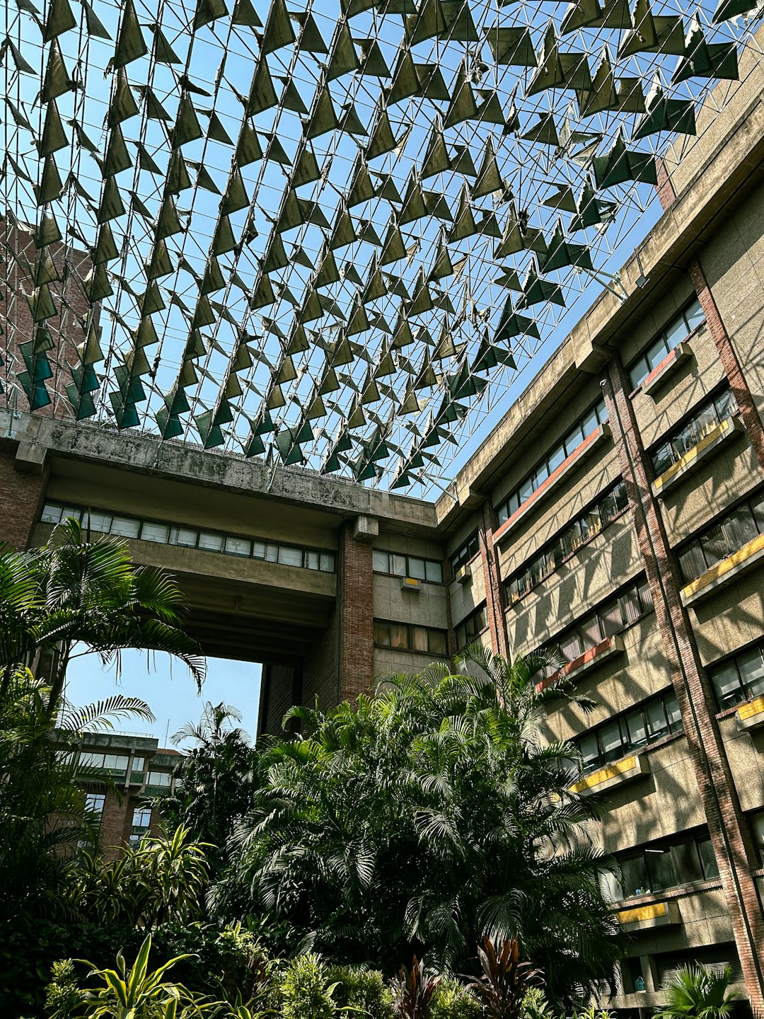 Brutalist building with courtyard garden and triangular roof.