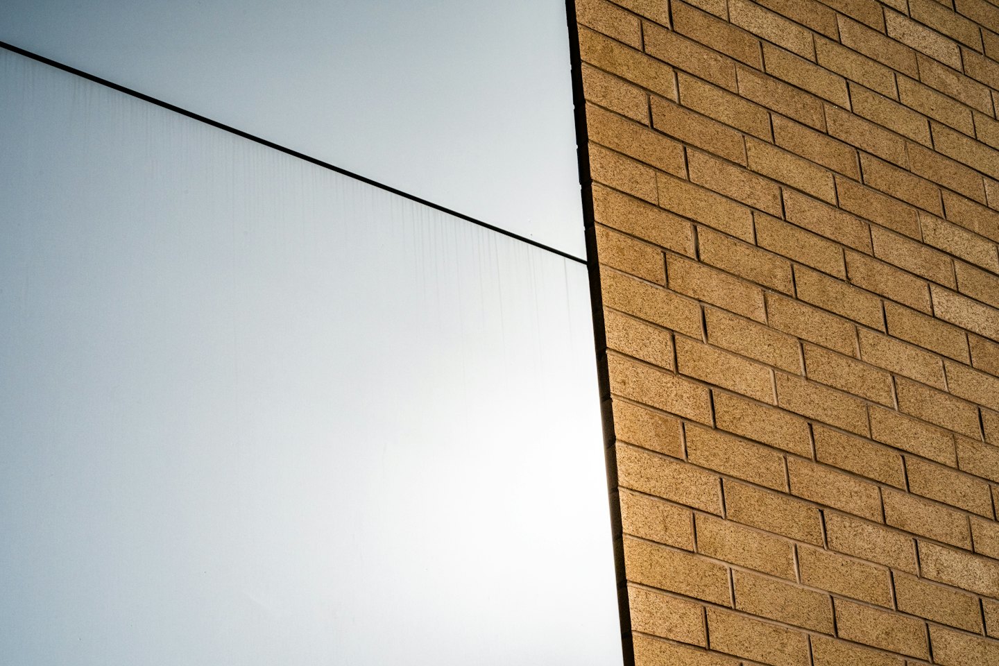 Modern office building exterior featuring glass panels and brown brickwork.